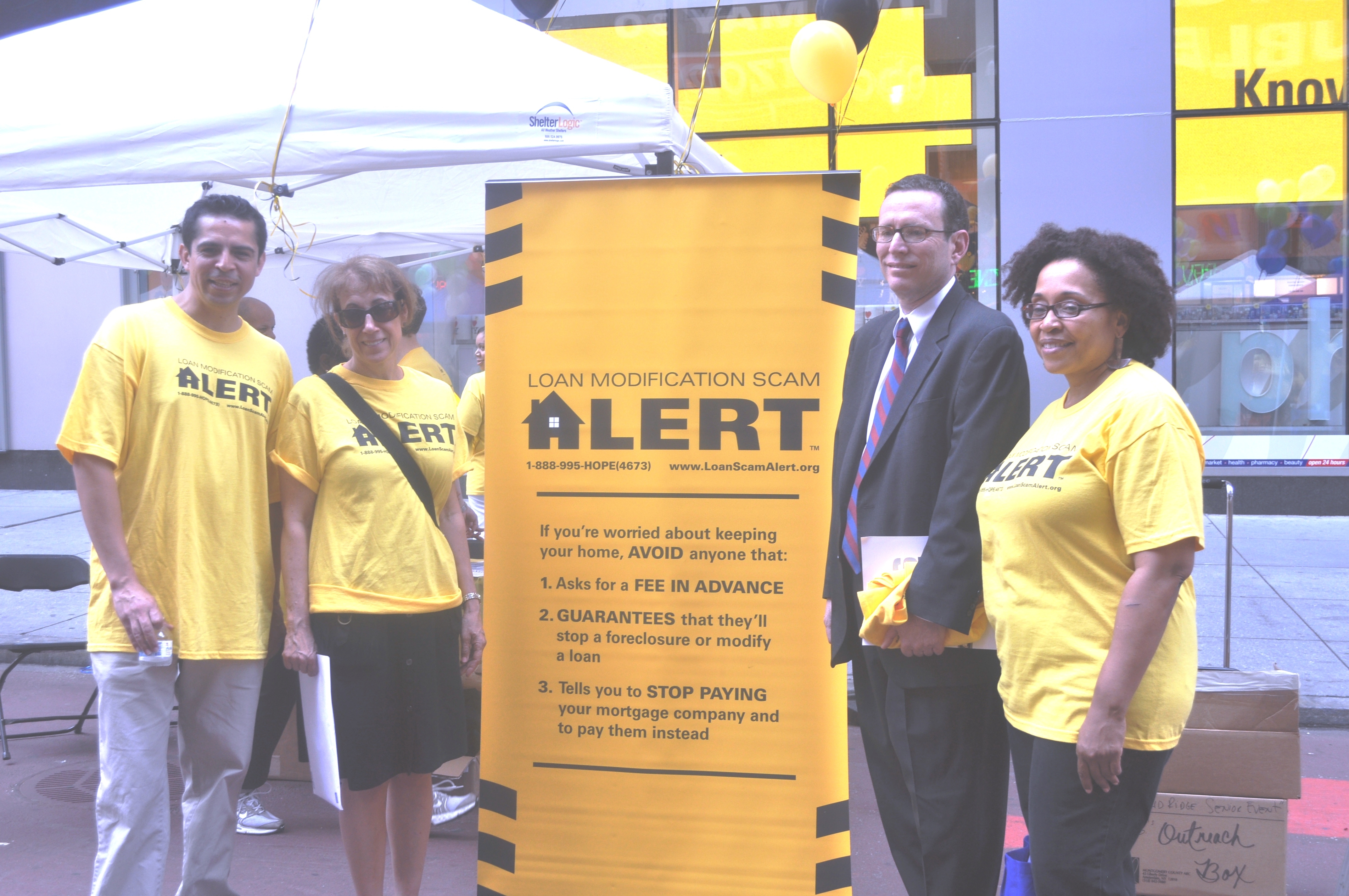 CPB staff Gary Brown and Edison Alban with representative from huosing advocacy groups in NYC's Times Square highlighting the problem of home foreclosure rescue scams